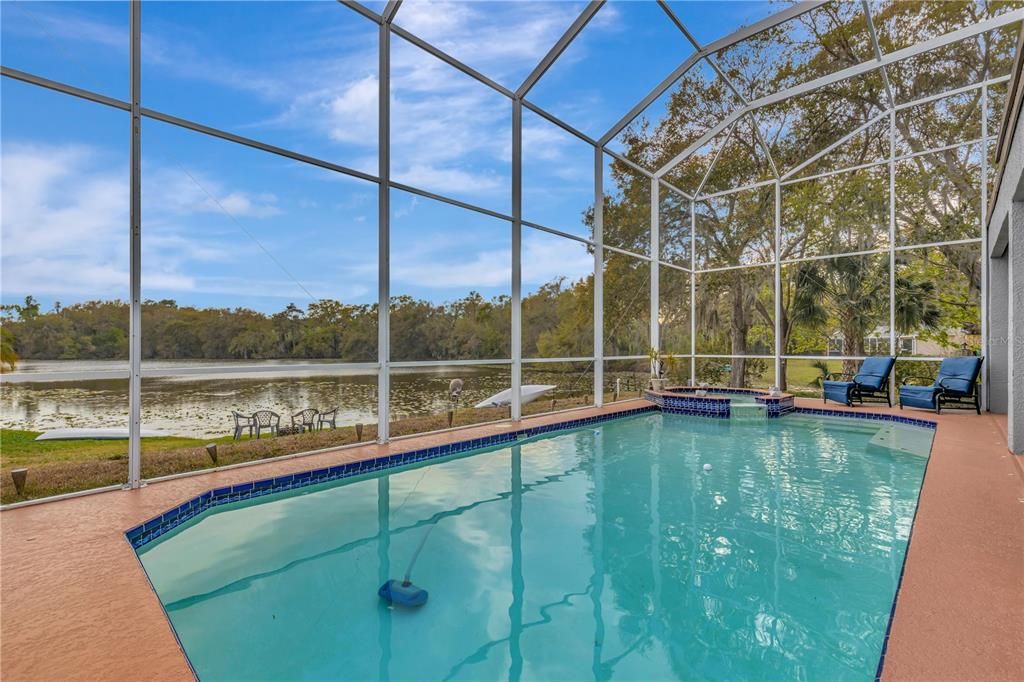 Heated pool with two story cage and balcony connects to second master upstairs and a guestbedroom.