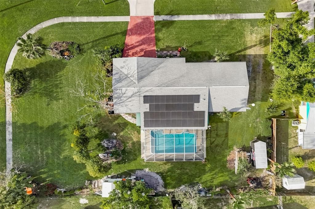 Top view of home showing roof, solar panels, and pool.