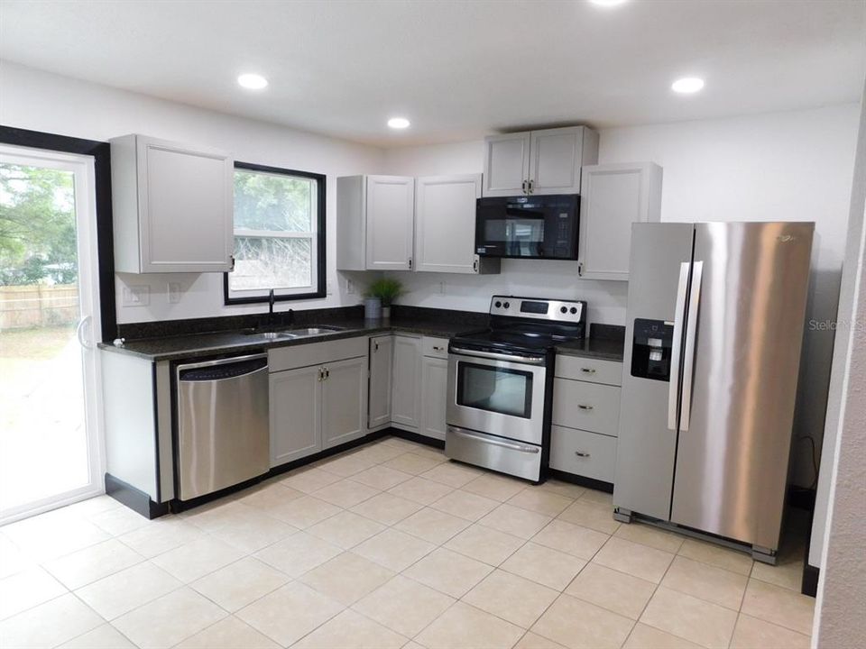 Beautiful Kitchen with new appliances & Slider leading out to the Back Yard