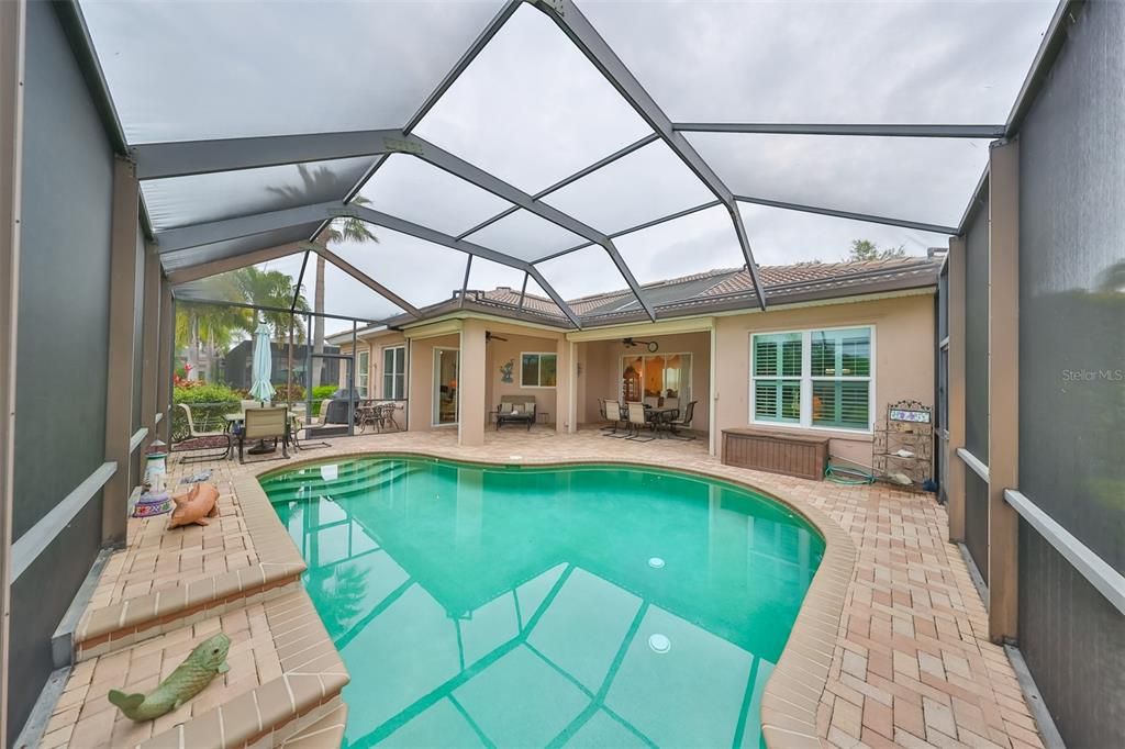 Stunning pool scene, with lovely, screened lanai allows you to relax, sit and watch the world go by. Enjoy a morning breakfast or evening meals with the breezes rustling the palms. From here you can see the golf course.