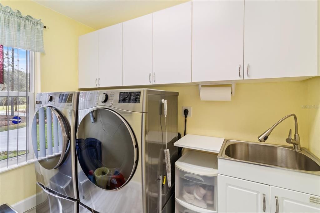 Inside laundry with cabinets and sink