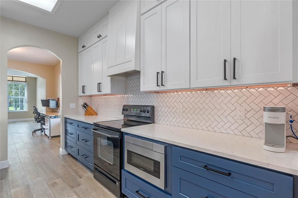 Updated kitchen with premium quartz, expanded cabinetry to ceiling and newer appliances