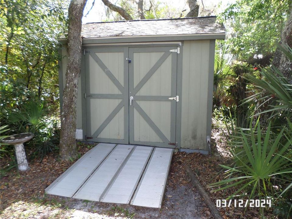 Storage shed with metal ramp.