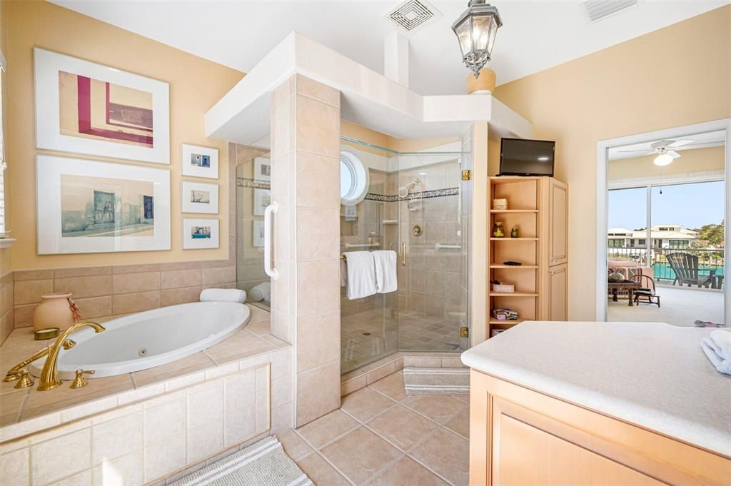 Primary bathroom has jetted corner garden tub, walk-in shower, built-in linen closet, and private water closet room