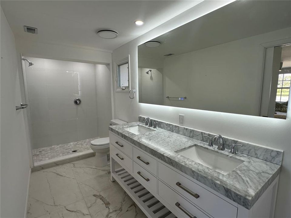 Master bath with step in shower and dual sinks.