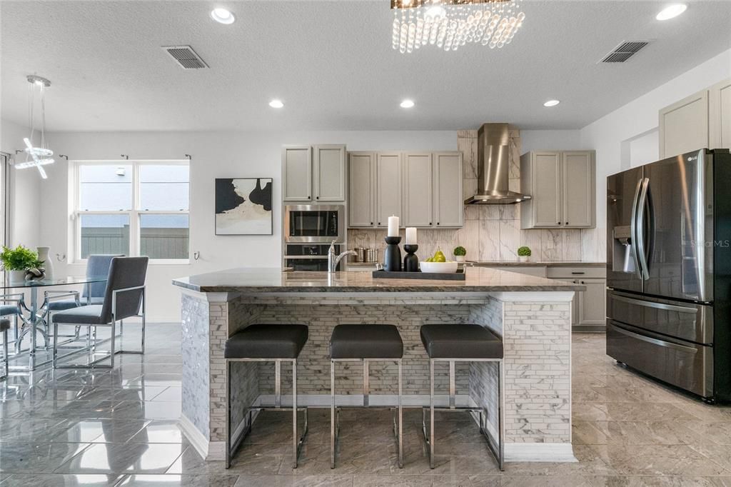 The kitchen showcases a large island with breakfast bar seating