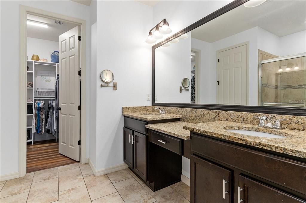 Primary bedroom's exquisite ensuite bath with shower and tub combination, elongated dual sink vanity and stairstep countertops. Very spacious walk-in closet conveniently located off bath.