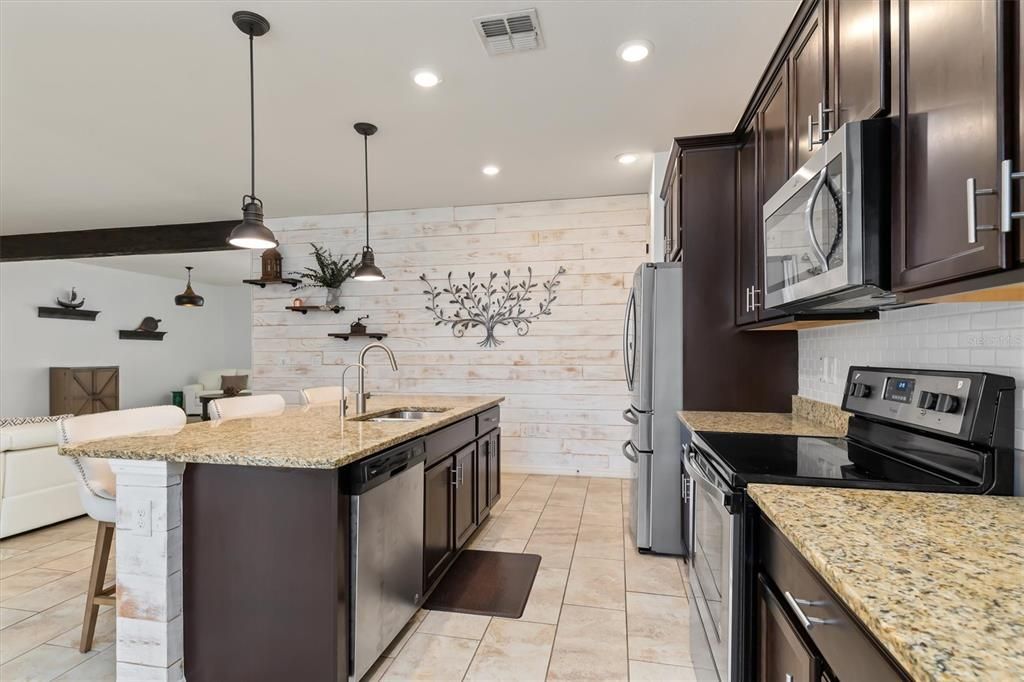 The deep breakfast bar granite countertop is perfect for food prep, entertaining, work, and so many other things.