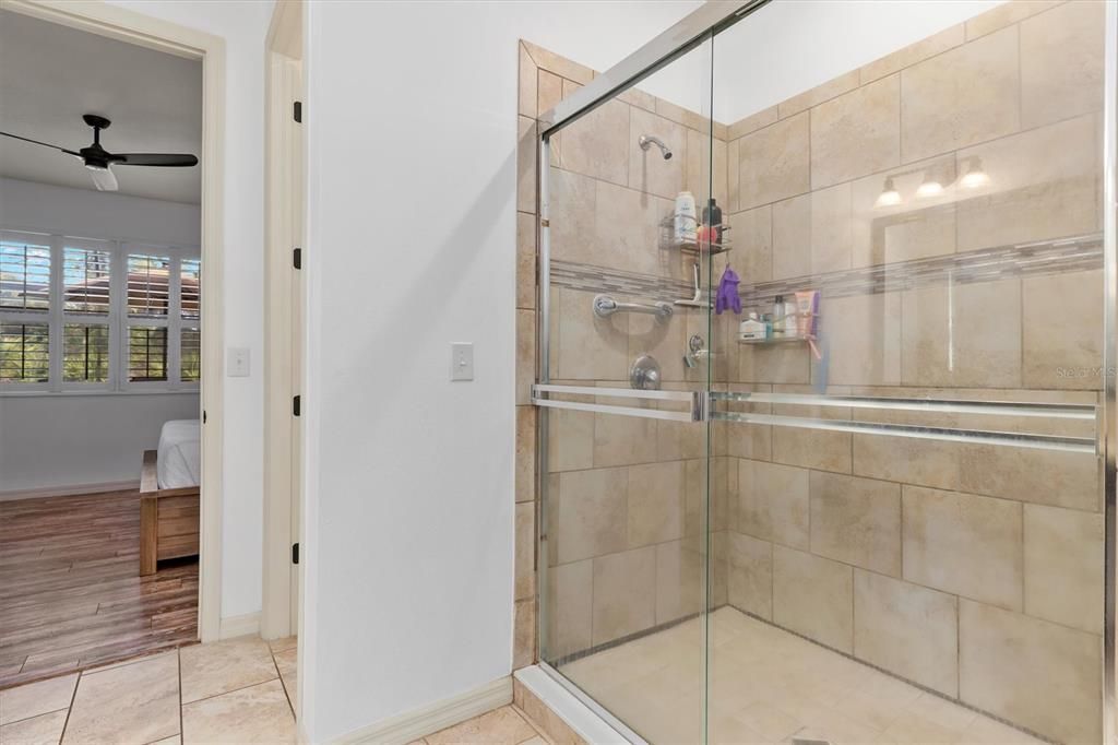 Spacious tiled shower with double sliding glass doors. Private water closet.