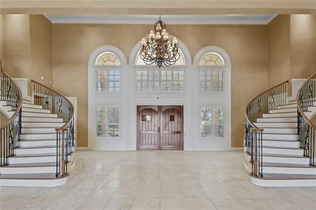 Grand foyer features mirroring staircase
