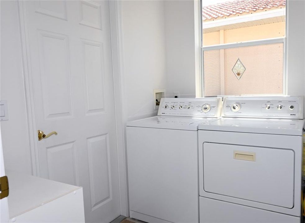Laundry room with utility tub and door to the garage