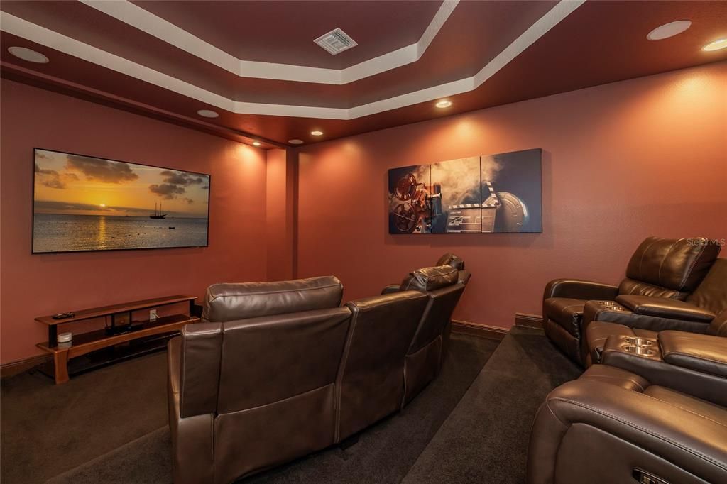 Theater room with wet bar and beverage refrigerator.