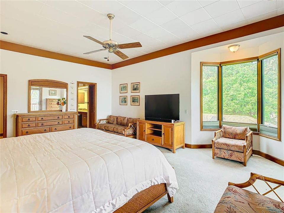 Primary bedroom has a bay beautiful bay window to add in natural light.