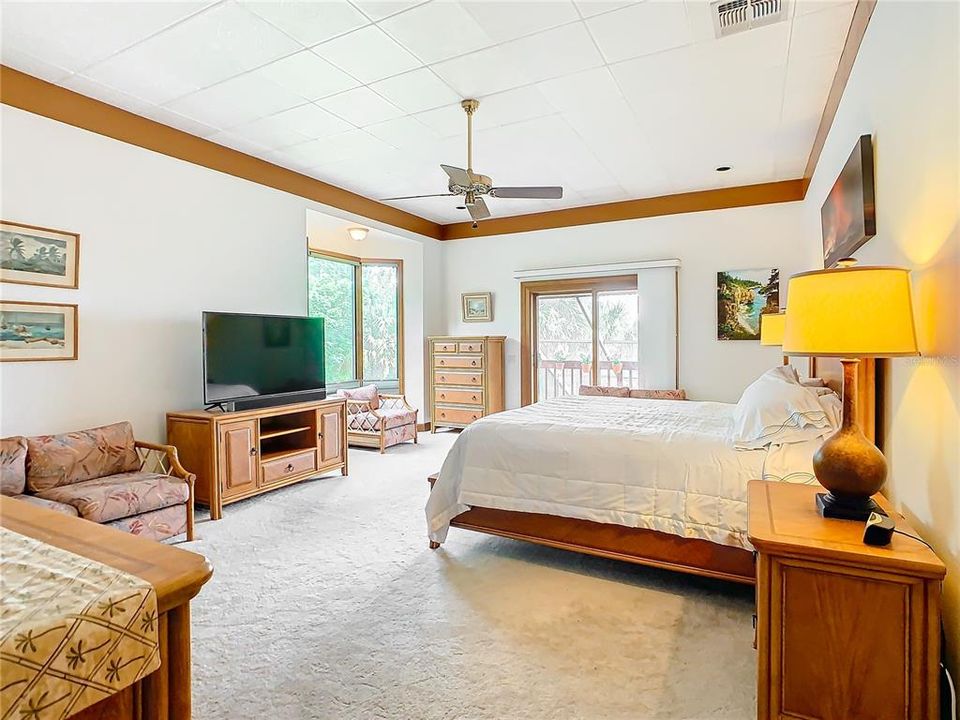 Primary bedroom with sliding glass doors that open to the up-stairs screened porch.