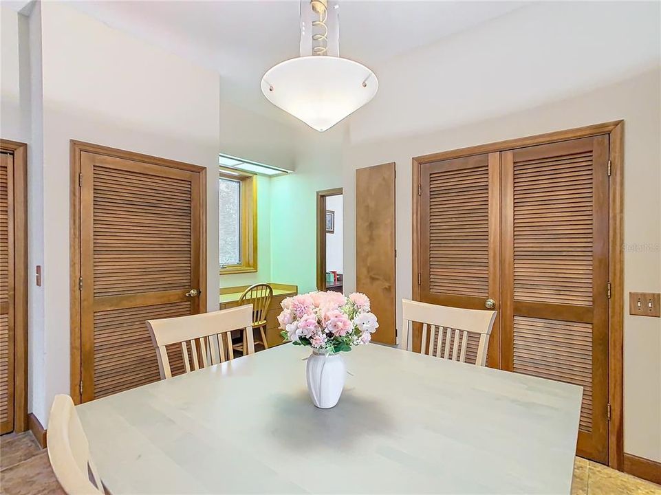 Dinette with storage behind the doors to the back right, and an extra refrigerator is behind the door to the back left.