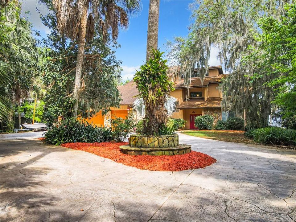 Circular driveway with 2 car attached garage, attached RV garage with 12' roll up door, and golf cart/lawn mower garage.