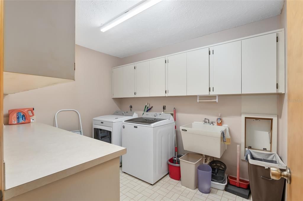 LARGE LAUNDRY ROOM WITH CABINETS AND TUB SINK