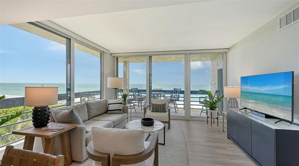 The living room features stunning west and south Gulf views with floor-to- ceiling impact windows and sliding doors that lead to the spacious terrace