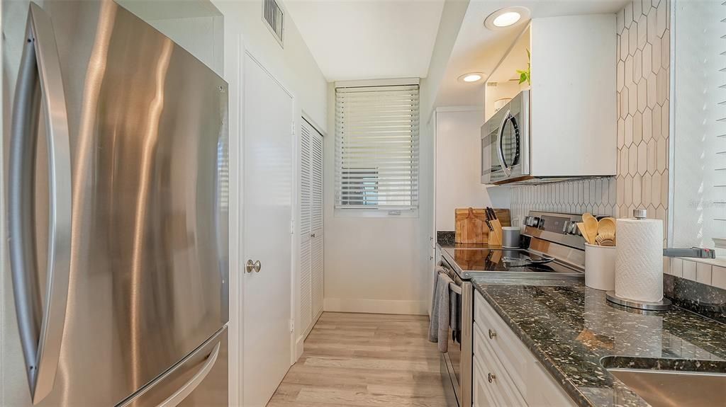 The updated kitchen is light and bright, with open shelving, granite counters,designer white backsplash and stainless appliances including new LG refrigerator and range