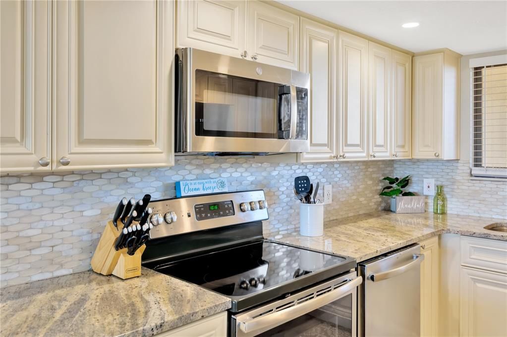 Luxury coordinating backsplash is an added compliment to wood cabinetry and granite countertops.