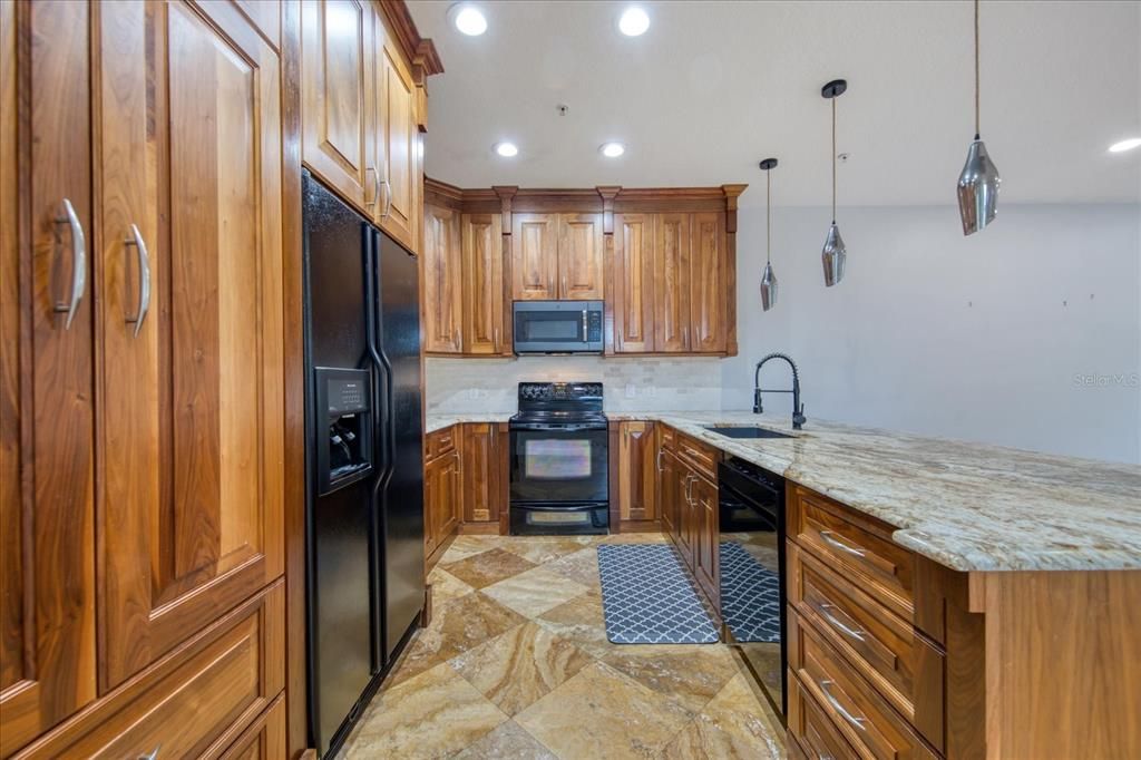 Kitchen with solid wood cabinetry and granite countertops.