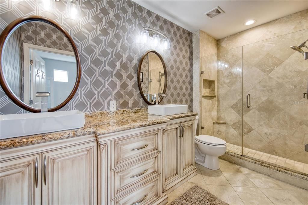 Primary bathroom with gorgeous tile work and dual vanity.