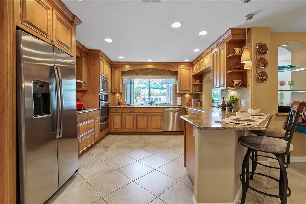 Huge custom kitchen with wood cabinetry, granite counters and ss appliances!
