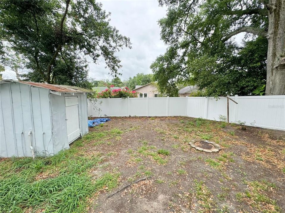 Rear fenced in yard with storage shed