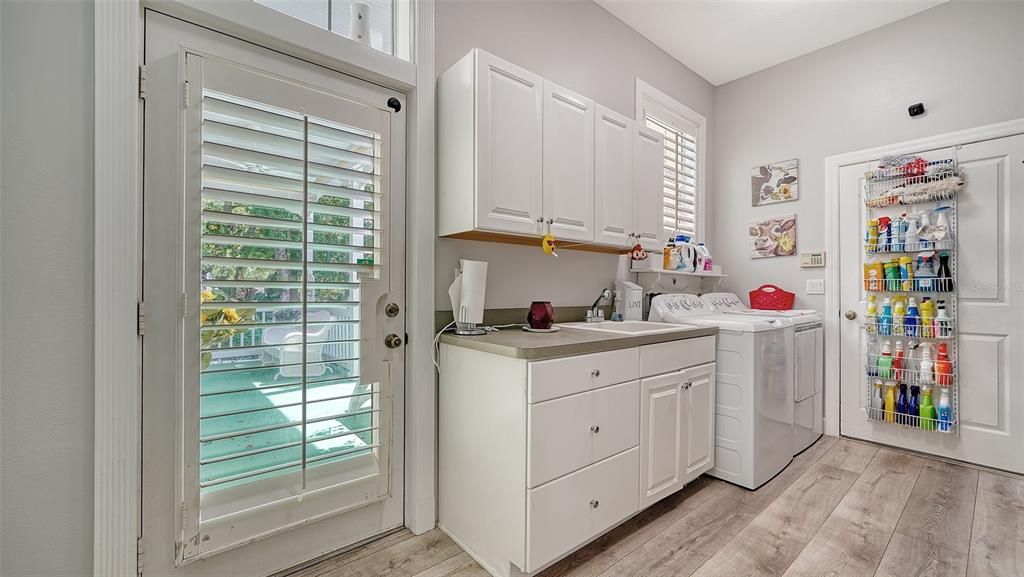 Generous size laundry room with cabinets and a large storage pantry closet