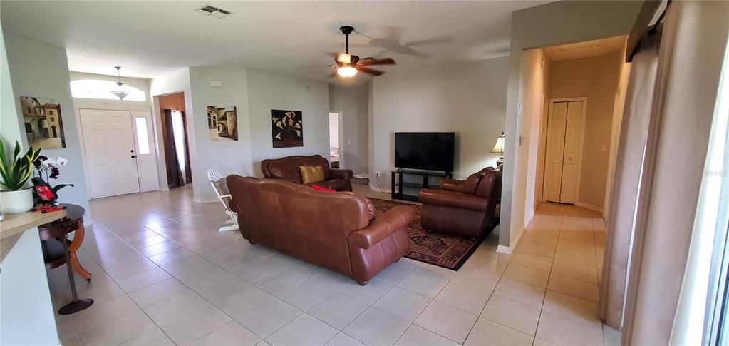This family room offers a nice size open plan with tile floor, ceiling fan.  Direct view to the foyer and the sliding glass door to the back porch.