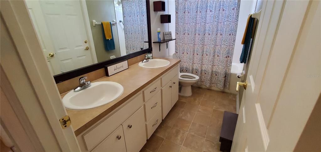 This is the guest bathroom.  It also has the double vanities as does the master bathroom.  There is a door that leads to the outside.