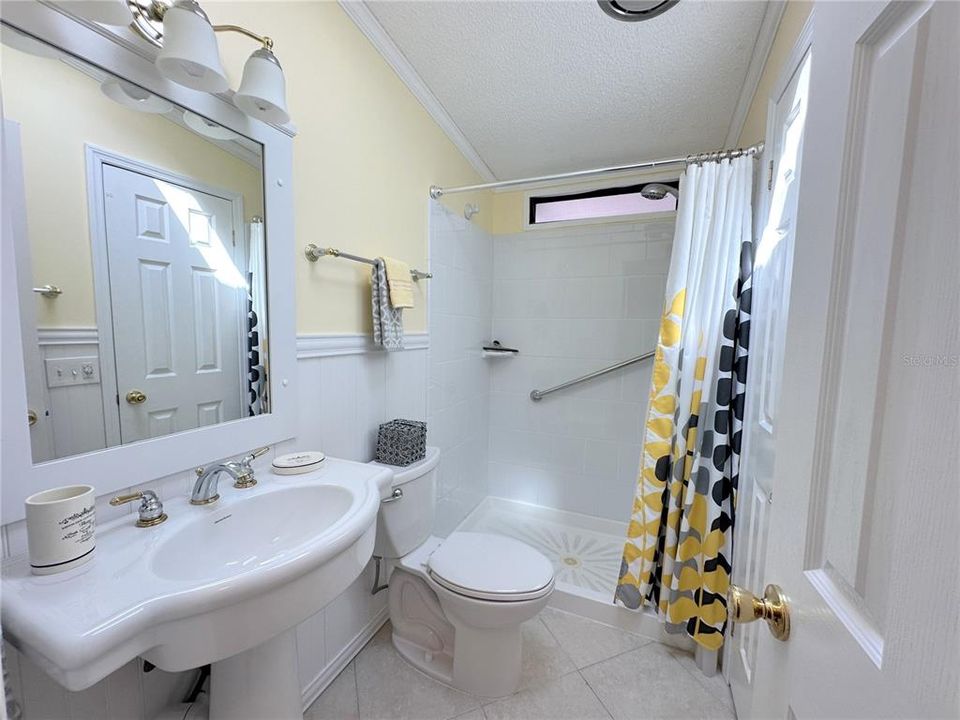 Guest Bath has pedestal sink and tub/shower combo