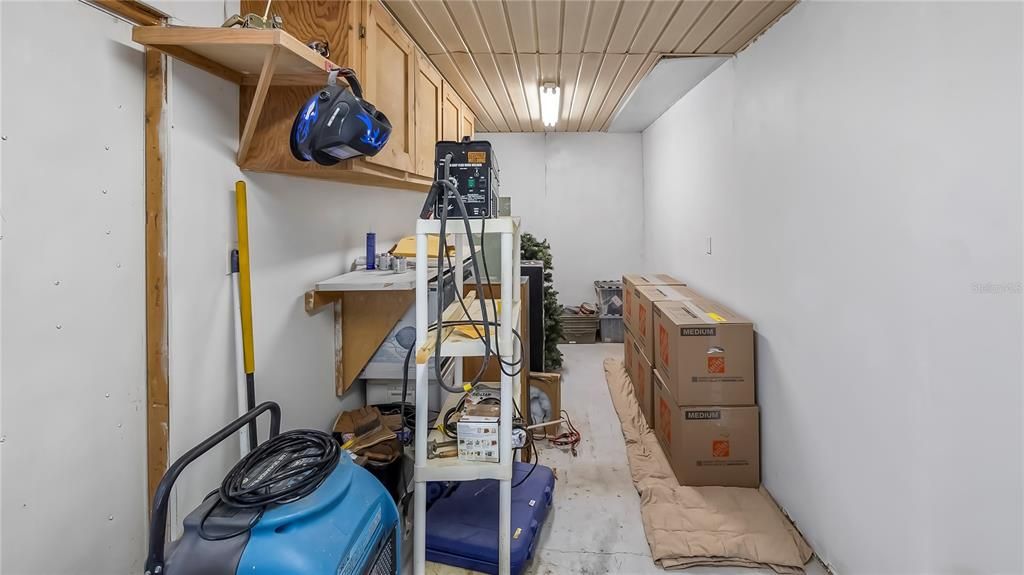 Utility room/workshop off of carport. Has double doors, could possibly store a golf cart in here.