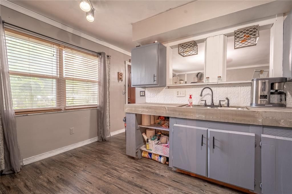 The kitchen features a large picture window and vinyl flooring.