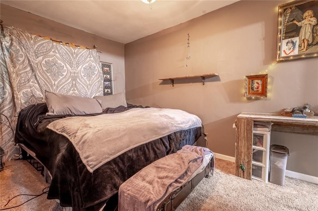 The primary bedroom is neutral tones with an ensuite bath, a ceiling fan and carpet.