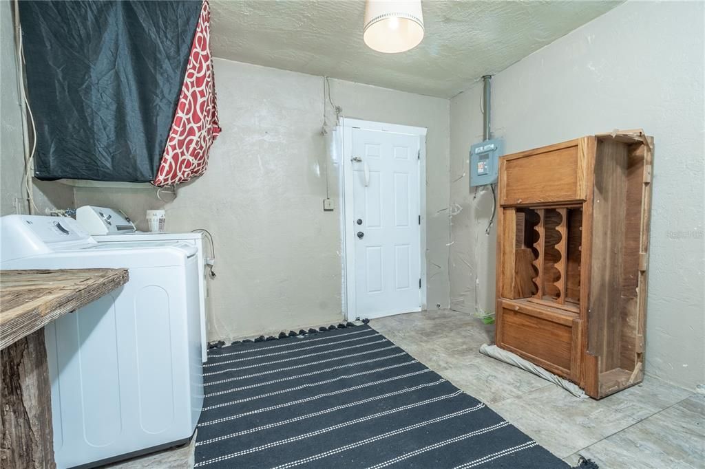 The laundry room features a washer/dryer and shelving.
