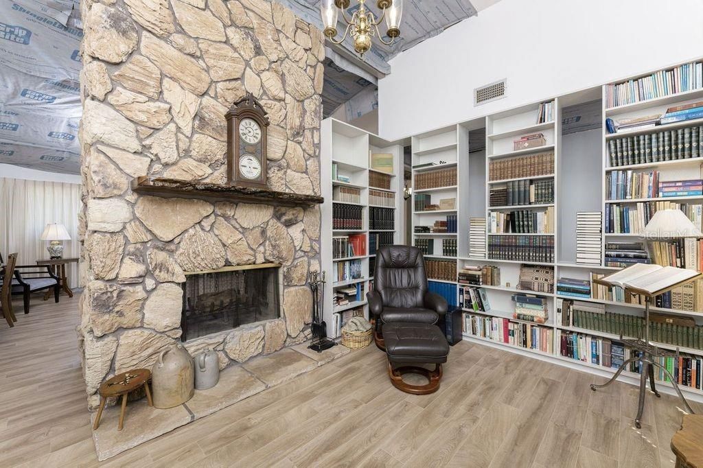 Library with a wood fireplace separating it from the formal living room