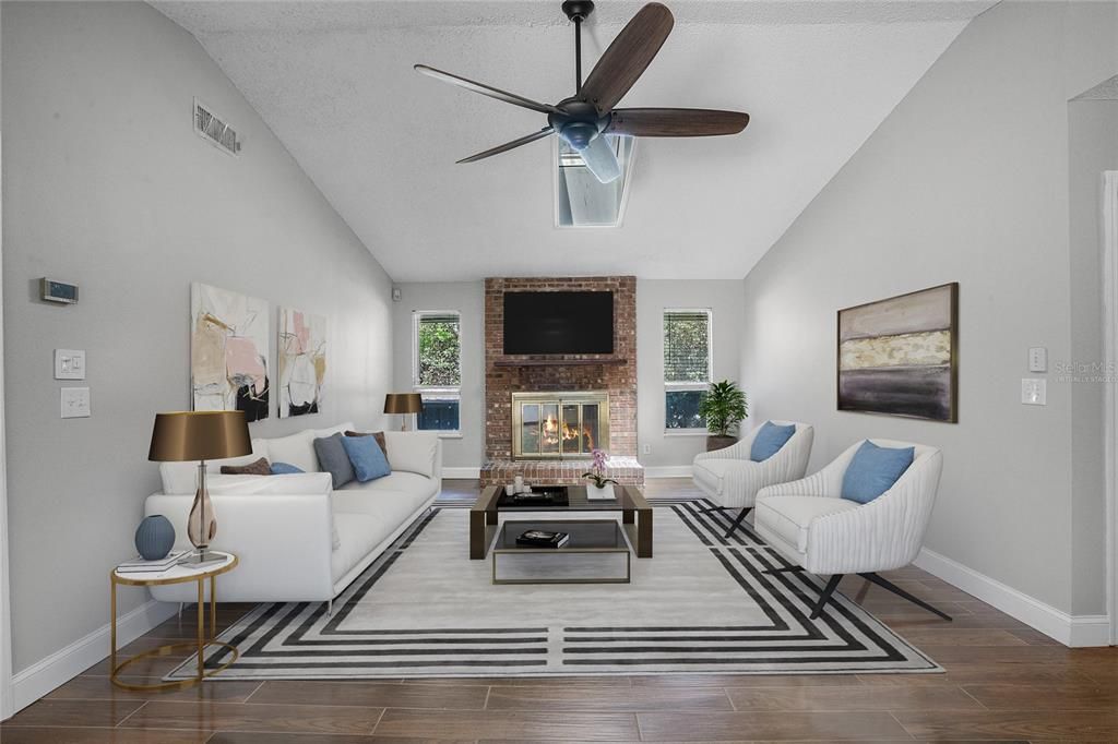 Wood look tile floors flow from the kitchen into a generous family room with a BRICK FIREPLACE to center the space under a VAULTED CEILING. Virtually Staged.