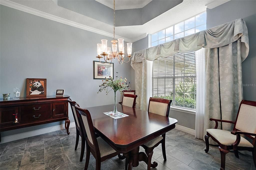 Formal dining room with tile, tray ceiling and elegant crown molding. Note all the natural light!