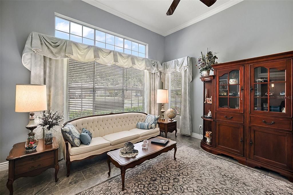 Formal living room with tile, crown molding, ceiling fan