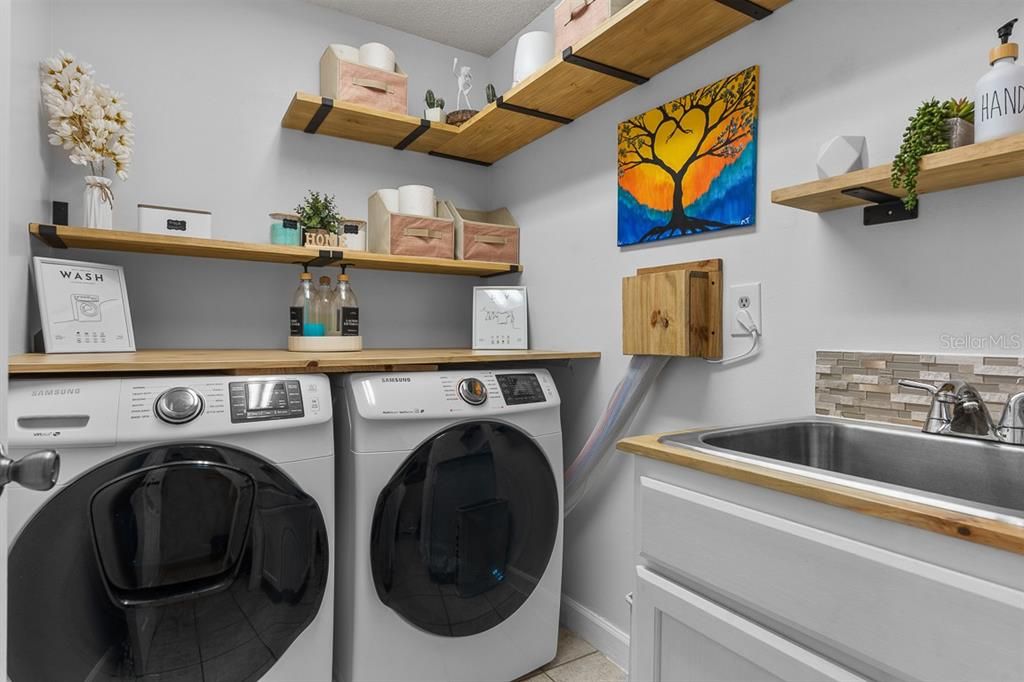 Renovated laundry room has plenty of folding space and a utility sink.