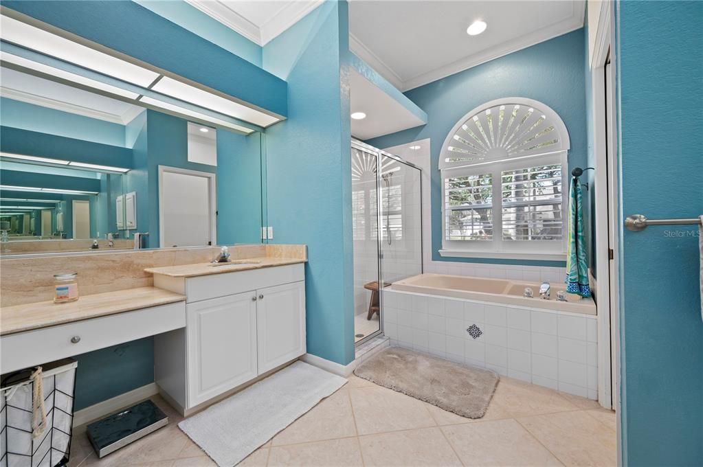 Primary bathroom with garden tub, separate shower, vanities with sinks on each side.