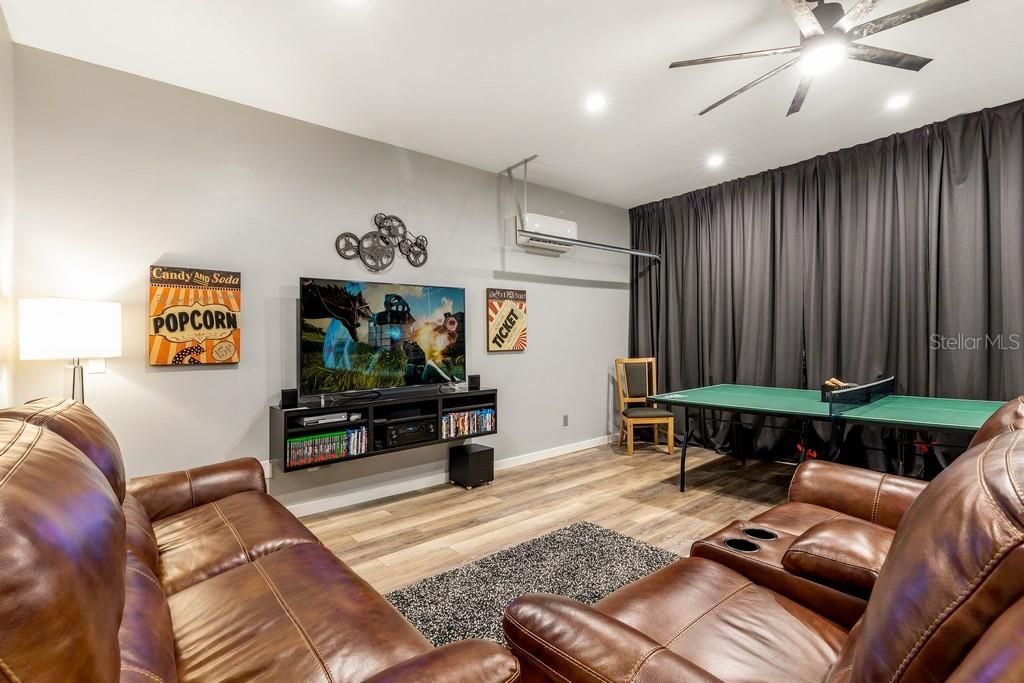 Amazing game room with cozy seating, plenty of games, TV and movies plus luxury vinyl floors and room A/C