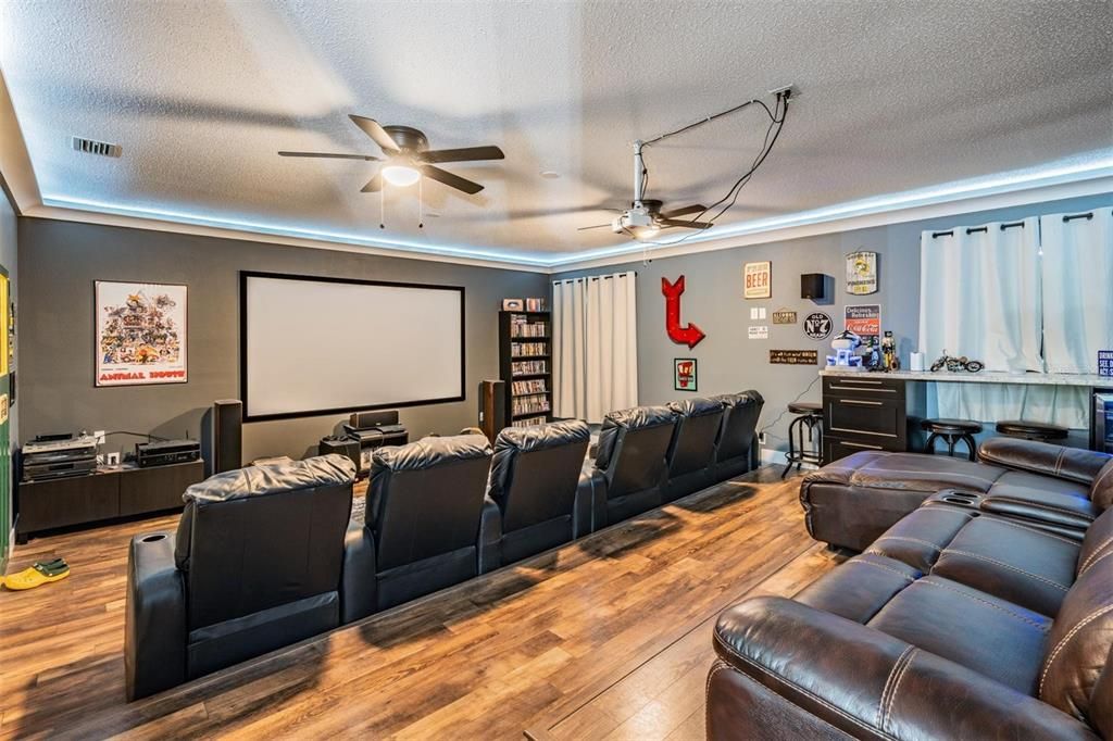 Huge Theater Room, new Flooring, Black out window curtains, ceiling fans and full bar area, up lights surrounding to tray ceiling,Remodeled space with tiered flooring to accommodate seating for 10 and Surround lighting, 100 Viewing Screen.