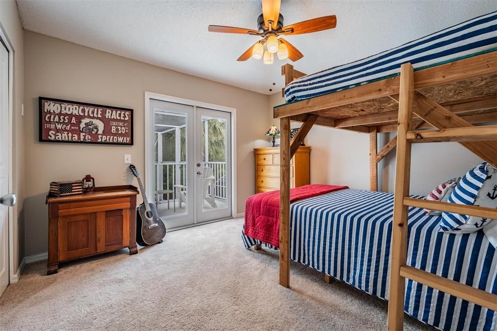 Large Guest room upstairs with double doors to the balcony overlooking the pool, pond and conservation.