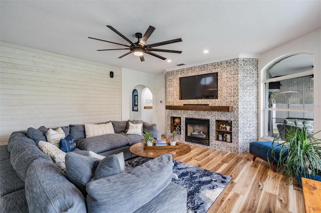 Huge, Open and lots of light in the Family Room, Custom Fireplace with new tile, Centered Fireplace and Shelving, New Water Resistant Laminate flooring, Ceiling Fan and views of the pool, conservation and pond.