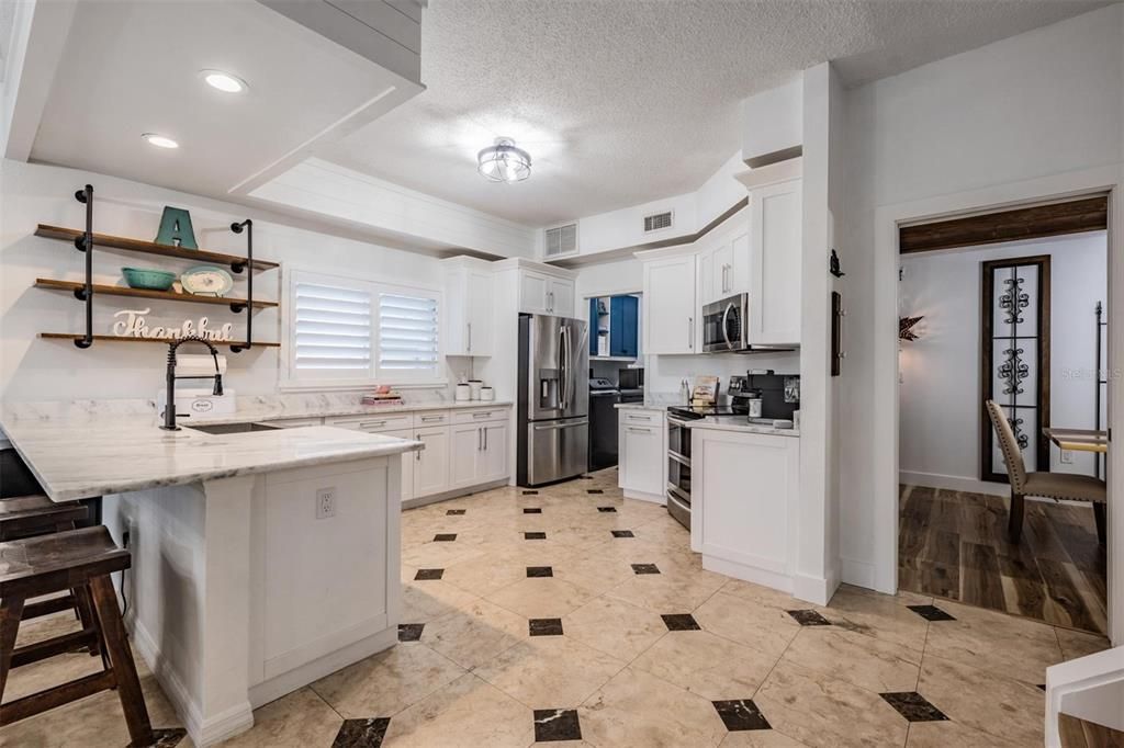 Chef's Kitchen! Marble Counter Tops, New faucet, New Fixture and newer Stainless Steel appliances, Farm sink, open storage bar area between dinette area and family room along with a Shiplap Bulkhead.