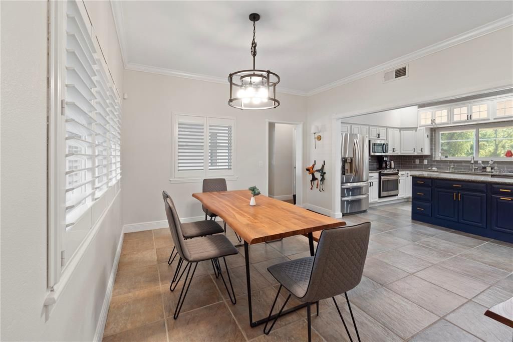The dining room is graced with plantation shutters and boasts high-quality tile flooring, ensuring easy cleanup while adding warmth to the space.