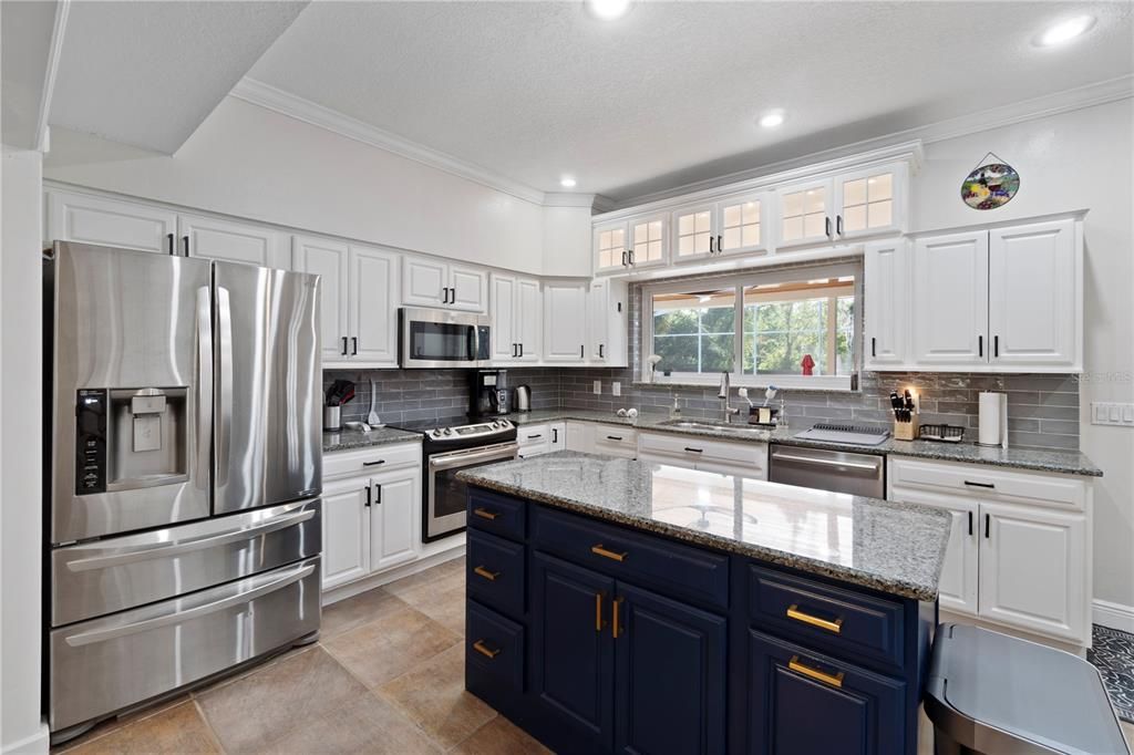 Step into a fresh and clean white kitchen adorned with granite countertops and a convenient kitchen island, perfect for effortless food preparation. Kitchen is also complemented by the addition of a brand new Bosch dishwasher, offering both elegance and functionality.