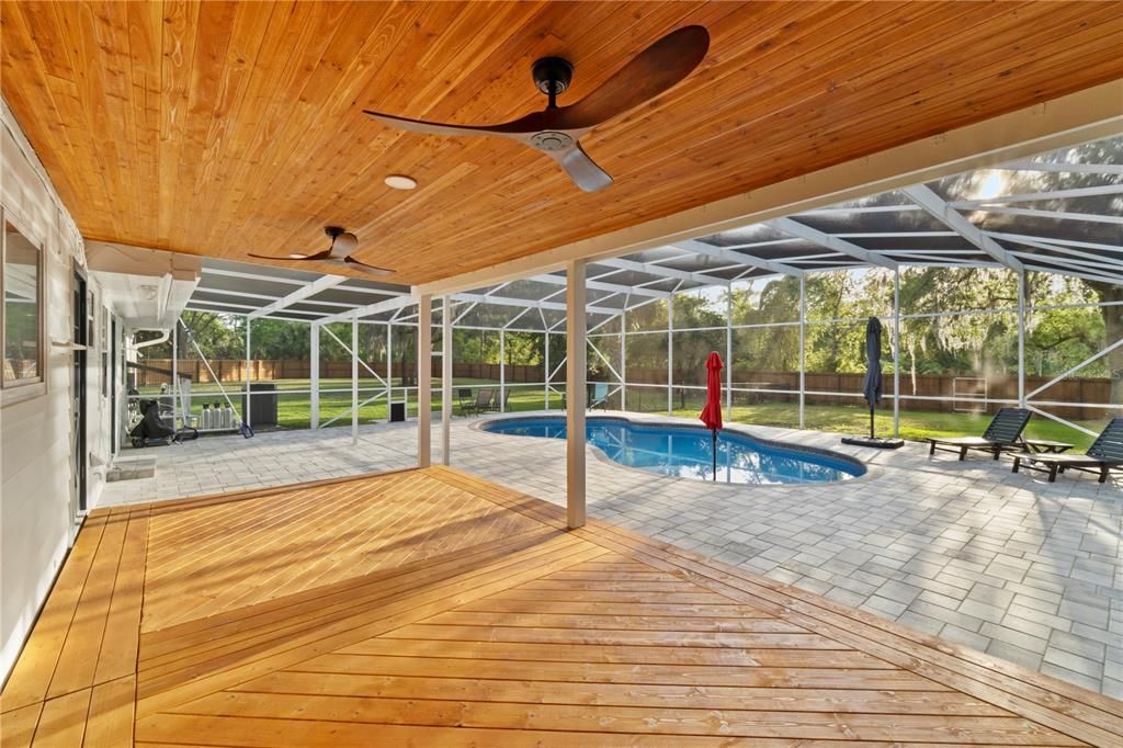 This newly constructed porch deck boasts a meticulously crafted wood design, perfectly complementing the freshly planked porch ceiling. Enhanced with top-quality fans, it promises to keep you cool and comfortable throughout the warm summer months.